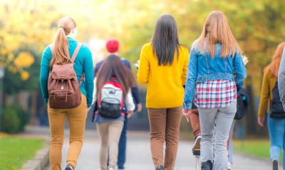 Back view of college students walking on campus
